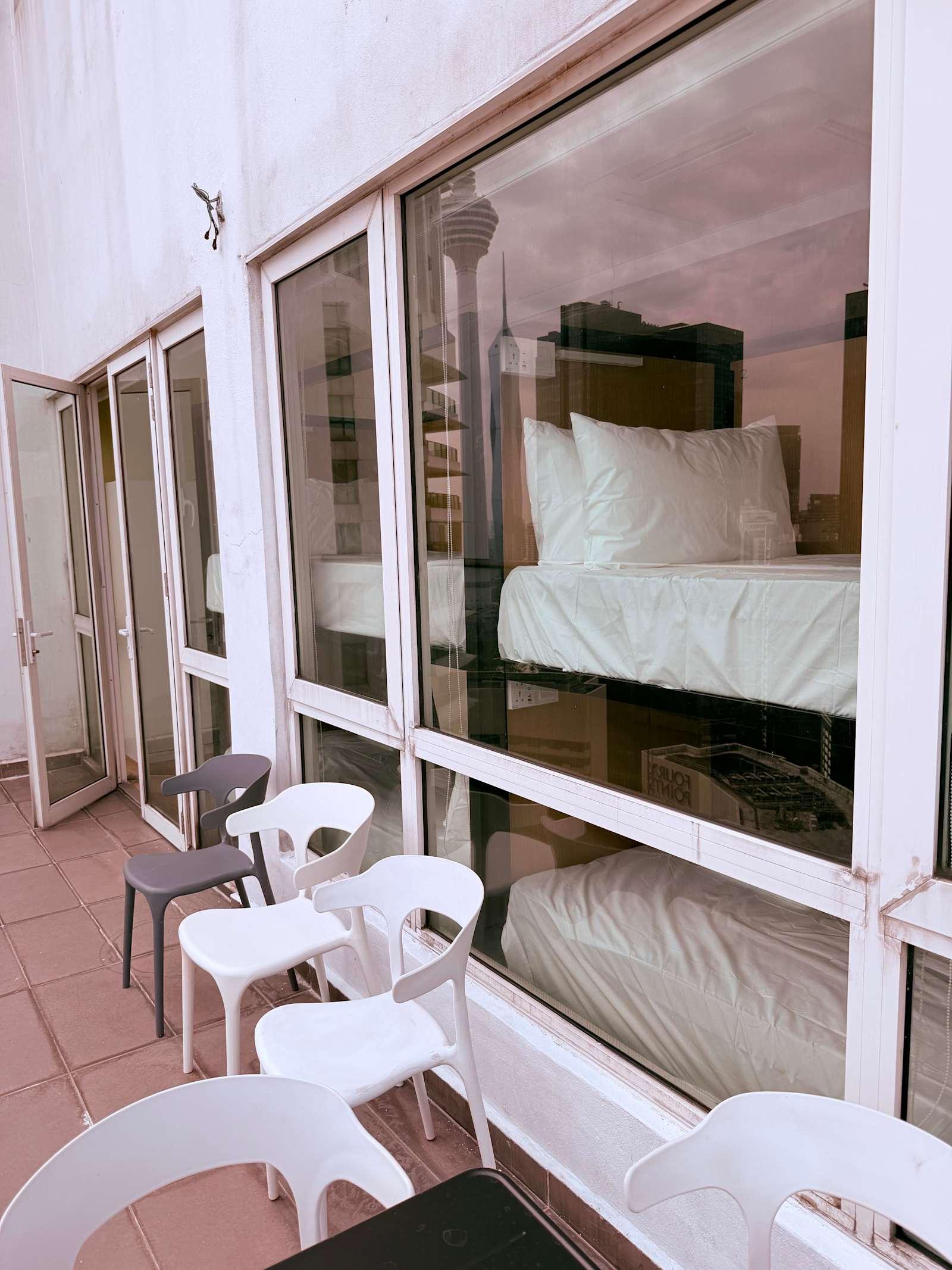 Balcony seating outside rooms at Crest Residence hostel